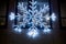 Beautiful snowflake styled cool white christmas lights in the night on a wall