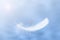 Beautiful Soft and Light White Feather Floating in the Sky with Clouds. Abstract. Heavenly Dreamy Fluffy Colorful Sky.