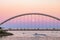 Beautiful soft pink colors at dusk with the full moon rising behind the Humber Bay Arch Bridge and Lake Ontario