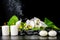 beautiful spa concept of blooming white orchid flower, phalaenopsis, green leaf with dew, smoke stick and candles on black zen st