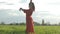 beautiful Spanish brunette woman in red dress dancing at sunset in wheat field