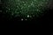 Beautiful, sparkling green glitter pouring down from above on a dark background