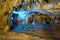 Beautiful speleothem stalagnata, stalactites, stalagmites in natural cave illuminated by color lights