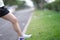 beautiful sport girl legs stand on wayside grass in morning before run with running shoe