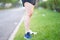 beautiful sport girl legs stand on wayside grass in morning before run with running shoe