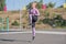 Beautiful and sportive blonde girl doing jumps on the street sports ground.