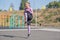 Beautiful and sportive blonde girl doing jumps on the street sports ground.