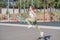 Beautiful and sportive blonde girl doing jumps on the street sports ground.