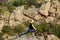 Beautiful sportive blonde girl training, stretching on rock in canyon.