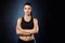 Beautiful sportive girl posing with crossed arms over dark background.