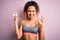Beautiful sportswoman with curly hair doing sport wearing sportswear holding diet reminder doing ok sign with fingers, excellent