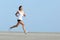 Beautiful sportswoman running with the sky in the background