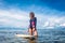 beautiful sportswoman in wetsuit standing at surfing board in ocean at Nusa dua Beach