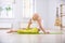Beautiful sporty fit yogi woman practices yoga lying asana Ardha Bhujangasana in the fitness room