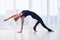 Beautiful sporty fit yogini woman practices yoga asana Camatkarasana - Wild Thing Pose in the yoga studio.