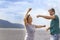 Beautiful sporty mature couple dancing on the beach on the Volga river against the background of the Zhiguli mountains