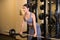 Beautiful sporty woman in good shape do exercises workout with barbell in a gym.
