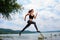 A beautiful sporty woman runing on the shore of a lake in sports