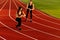 Beautiful sporty woman and young sporty man are ready to run on racetrack.