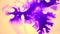 Beautiful spreading purple ink drops on yellow wet smooth surface