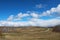 A beautiful spring day in the countryside. The blue sky in the clouds and the road that goes into the distance. Early spring.