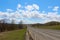 Beautiful spring day after rain in the countryside. Blue sky in the clouds and a road stretching into the distance. Early spring.