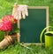 Beautiful spring flowers and blackboard blank on the green grass