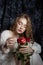 Beautiful spring girl is sitting on the floor with rose flowers in her hands. Woman in a white dress is dreaming, a romantic image