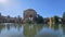 A beautiful spring landscape at Palace of Fine Arts with a lake, lush green trees and plants and beautiful buildings with blue sky