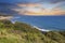 a beautiful spring landscape at Point Dume beach with blue ocean water, lush green trees and plants, homes along the cliffs, waves