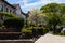 Beautiful Spring Sidewalk Scene with Old Homes and Green Gardens in Astoria Queens New York