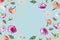 Beautiful spring or summer layout with different flying flowers and leaves on pastel blue background, trendy floral frame