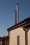 Beautiful stainless steel pipes on the roof of a small house against a blue sky