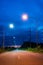 A beautiful starlight vertical view of orange and white lanterns beside a country road