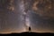 Beautiful starry night, photographer silhouette with camera looks at the Milky Way galaxy. Night landscape, astronomical backgroun