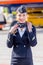 Beautiful stewardess dressed in official dark blue uniform of Aeroflot Airlines on airfield. Passenger jet aircraft on background.