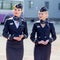 Beautiful stewardesses dressed in official dark blue uniform of Aeroflot Airlines on airfield.