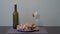 A beautiful still life with a bottle of wine, a glass glass and live grape snails crawling on a plate and a glass on the