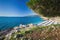 Beautiful stone beach with crystal clear tourquise sea surrounding by pine tree in Croatia, Istria, Europe