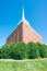 Beautiful stone church with white spire - clear vivid blue skies with lush green bushes in front - wide angle - green, brown, whit