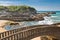 Beautiful stone walking footbridge over sandy beach in touristic destination surf spot with turquoise ocean and waves in biarritz