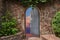 In the beautiful stone wall the iron door is ajar