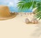 Beautiful straw hat with shells, palm leaf on the ocean coast and blue sky. Nature summer background