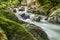 Beautiful stream cascade over pretty green moss covered stones