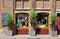 Beautiful street cafe old brick facade, display windows, olive trees