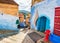 Beautiful street in Chefchaouen city in Morocco with bright walls and traditional carpets