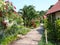 A beautiful street with small. cream and brown painted houses with palm trees and flowers.