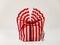 Beautiful striped packing bag tied with a red ribbon with a bow. Gift wrap. Nice gift, surprise.