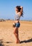 Beautiful strong enjoying woman posing on the beach in blue shor