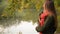 Beautiful student girl talking on mobile phone in fall. Autumn Caucasian woman having smartphone conversation in the